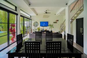 a living room with a table and chairs and a couch at Lush 3 BR enclose living room next to Canggu beach in Canggu