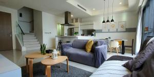 a living room with a blue couch and a table at MCity Ampang City view with infinity Pool in Kuala Lumpur