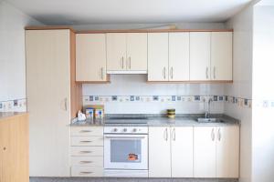 a kitchen with white cabinets and a white oven at Casa San Martiño - Teo in Rua De Francos +22 photos