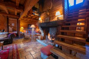 a living room with a fireplace in a log cabin at Chalet Tré la Vieux - Happy Rentals in Chamonix-Mont-Blanc
