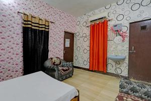 1 dormitorio con cama, silla y lavamanos en OYO The Home en Lucknow