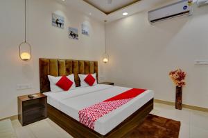 1 dormitorio con 1 cama grande con almohadas rojas en Flagship Hotel Orchid, en Ludhiana