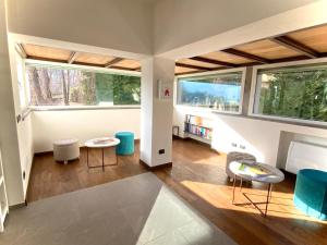 salon z dwoma stołami i dwoma oknami w obiekcie HARTMANN FEEL AT HOME B&B Villa Gignese w mieście Gignese