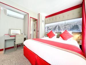 a hotel room with a large bed with red pillows at Best Western Nouvel Orléans Montparnasse in Paris +33 photos