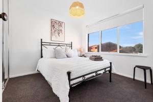 a white bedroom with a bed and a window at Lakeside Mews in Grange