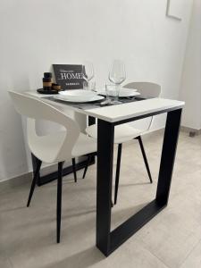 a table with two chairs and a table with wine glasses at Home Sweet Home in Siracusa +11 photos