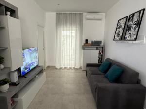 a living room with a couch and a flat screen tv at Home Sweet Home in Siracusa