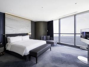 een slaapkamer met een bed, een bureau en een televisie bij 青岛海天大酒店 in Qingdao