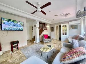 a living room with a couch and a tv on a wall at Macarena House & Chill Out in Benidorm