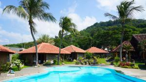 un complejo con piscina y palmeras en Watu Dodol Hotel & Restaurant, en Banyuwangi