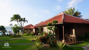 een huis met een rood dak en een tuin bij Watu Dodol Hotel & Restaurant in Banyuwangi