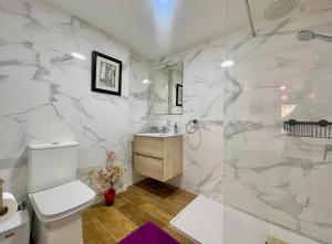 a bathroom with a white marble wall at Macarena House & Chill Out in Benidorm +23 photos