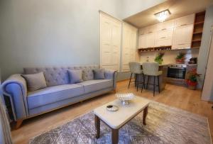 a living room with a blue couch and a table at STEMA Kalymnos in Kalymnos