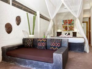 a living room with a couch and a bed at Mwezi Boutique Resort in Jambiani