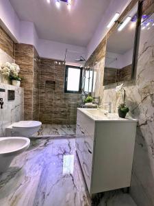 un ampio bagno con due lavandini e servizi igienici di Jolie Studios & Apartments a Eforie Nord