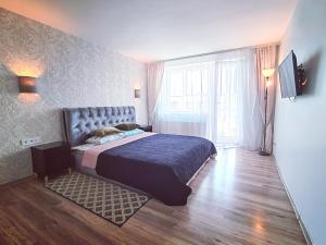 a bedroom with a bed and a large window at Cozy 3 bedroom apartament in town centre of Joniškis in Joniškis