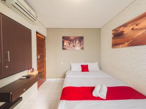 ein Schlafzimmer mit einem großen Bett und einem TV in der Unterkunft Beranda Plus near Hayam Wuruk 2 in Jakarta