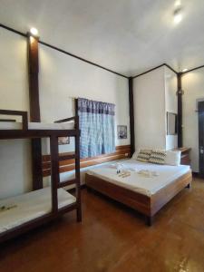 a bedroom with two bunk beds and a window at Anaya Inn and Restobar in Panglao