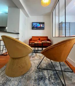 een woonkamer met 2 stoelen en een bank bij Élégant Studio en Hypercentre dans le Quartier Historique Animé avec Parking Gratuit in Caen