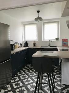 une cuisine avec un évier et une table avec deux fenêtres dans l'établissement Bel Appartement , proche tram place de Strasbourg accès centre ville, plages, à Brest
