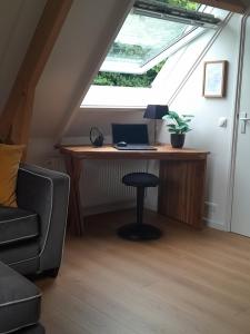 a desk in a attic with a laptop computer on it at Top appartement Short Stay in mooie omgeving Kortenhoef. in Kortenhoef