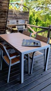 a table and chair on a deck with a book on it at Domek letniskowy in Antonowo