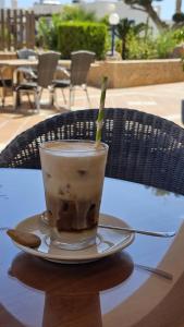 een kopje koffie op een bord op een tafel bij Hotel Puntazo II in Mojácar