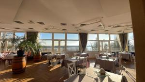 a restaurant with tables and chairs and large windows at Geovita w Jadwisinie in Jadwisin