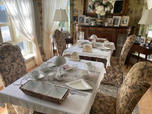 un comedor con 2 mesas y sillas con platos blancos en Ballybur Lodge, en Grange