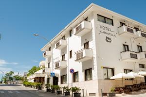 un edificio de hotel con mesas y sombrillas en Hotel La Caravella, en Vieste