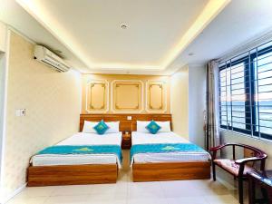 a bedroom with two beds and a window at Ha Linh Hotel DB - by BAY LUXURY in Diện Biên Phủ