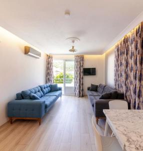 uma sala de estar com sofás azuis e uma mesa em Özgüm Suite Otel em Datça