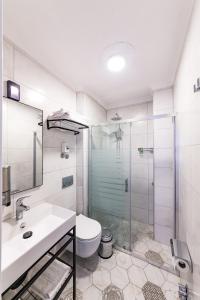 a bathroom with a toilet and a sink and a shower at Özgüm Suite Otel in Datca