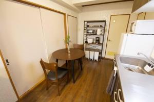 a small kitchen with a table and a refrigerator at ビスタ池上 301 in Tokyo