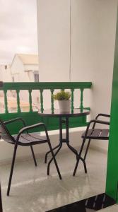 翁達海灘的住宿－Casa Pancho Lanzarote，阳台上的绿桌和盆栽植物