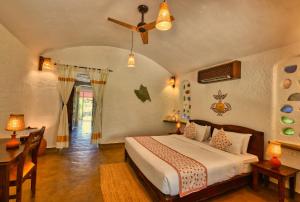 een slaapkamer met een bed en een plafondventilator bij The Earth at Ranthambore in Sawāi Mādhopur