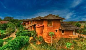 uma antiga casa de tijolos com telhado em The Earth at Ranthambore em Sawai Madhopur