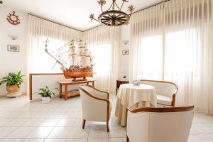 una habitación con una mesa y un barco en la pared en Hotel La Caravella en Vieste
