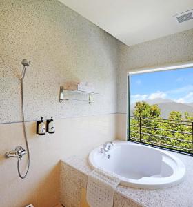 仁愛鄉的住宿－清境 百里莊園 Baili Manor Cing Jing，带浴缸的浴室和大窗户