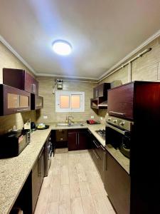 a large kitchen with wooden floors and a large counter top at New Maadi Apartment Families Only in Cairo