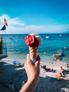 拿坡里的住宿－Ostello Bello Napoli，手持冰淇淋在海滩上