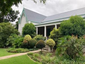 a house with a green roof and some bushes at Robertson Victoriaan in Robertson