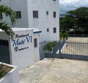 ein weißes Gebäude mit einem Schild für eine Matrix vm in der Unterkunft Residencial Maite Vl in Santiago de los Caballeros