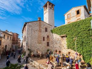 a group of people standing outside of a building with a tower at Belvilla by OYO Colombaia in Mantignana