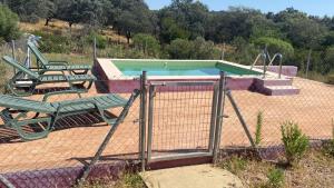 a swimming pool with two chairs and a swing at LA CHOCITA in Aracena