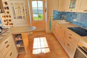a kitchen with a sink and a table in it at 687-Villa Kerguelen a 100m de la plage in Audierne