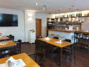 a restaurant with wooden tables and chairs and a bar at Villa Merry przy promenadzie i blisko Plaży - an der Promenade und in Strandnähe in Świnoujście