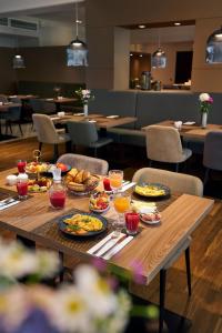 a table with plates of food on it in a restaurant at NH Berlin Kurf&uuml;rstendamm in Berlin
