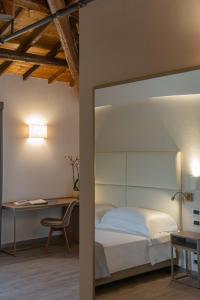 una camera con letto, scrivania e sedia di Le Cappuccinelle Suites&SPA a Perugia