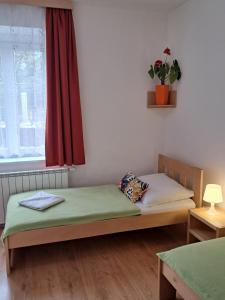 a bedroom with two beds and a window with a plant at Hotel Garni Rambousek in Prague